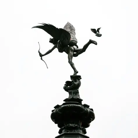 Statue of an angel holding a bow and arrow, standing on top of a pillar