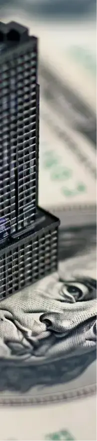 Black tower standing on top of a $100 dollar bill
